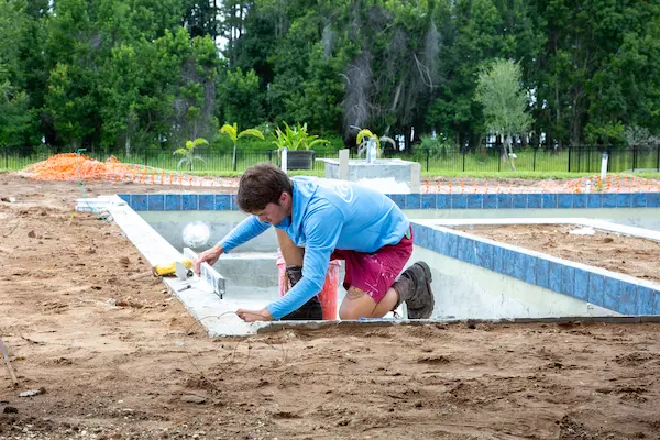 Pool design mistakes being mitigated with proper construction practices by Premier Pools worker on Orlando pool.