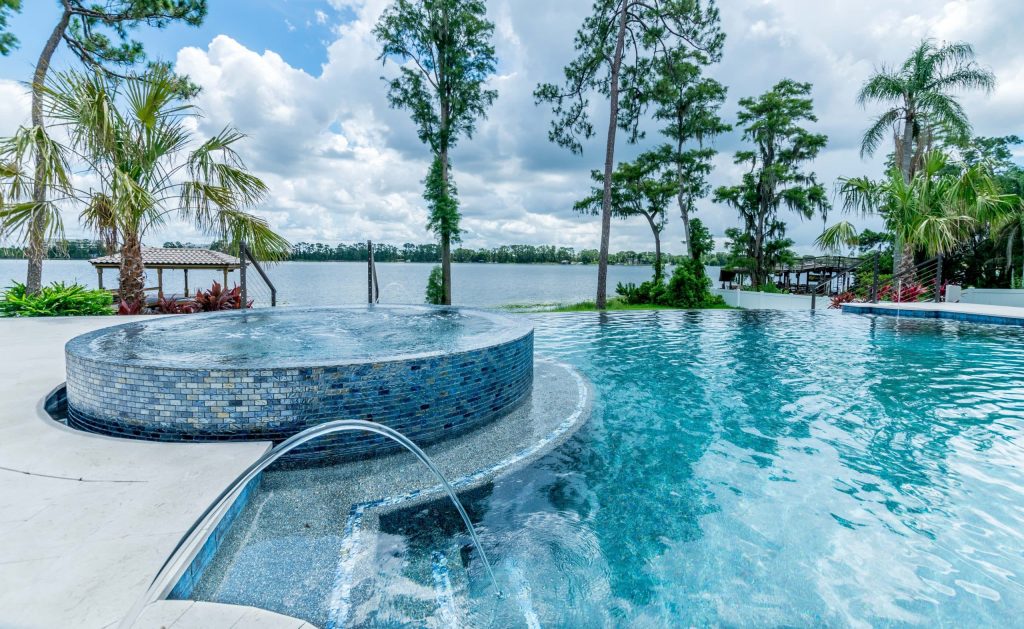 Hot tub with water features on infinity pool by a lake