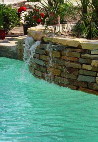 Water coming from faux rock formation on pool