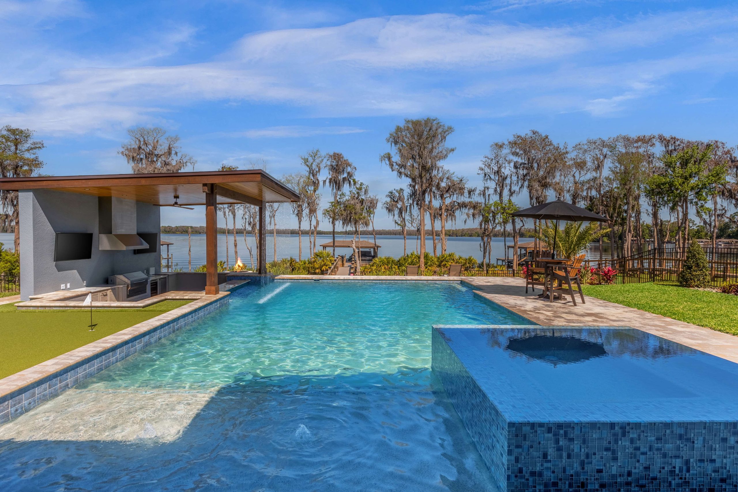 New Smyrna Beach Pool Builder completed on the water with pool bar and hot tub