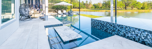 White Marble Infinity pool with a sun shelf, bar seating area, and spa