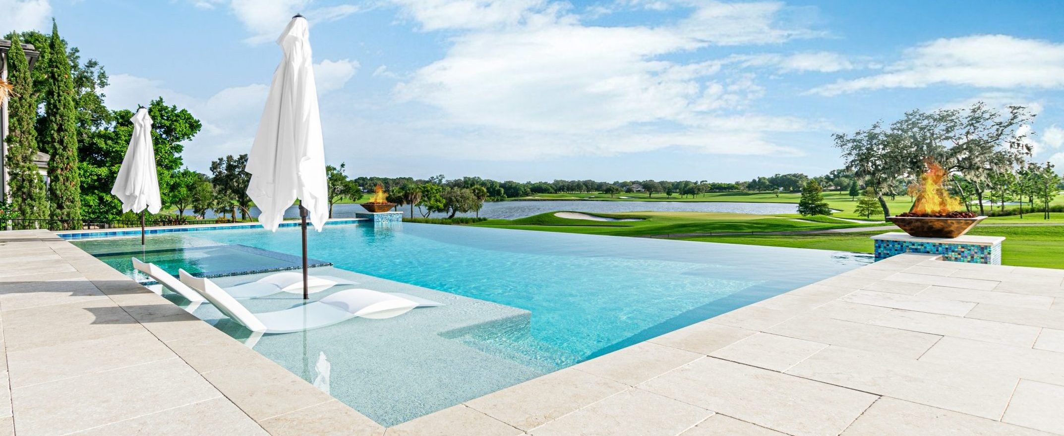 Infinity pool with dual fire bowls and a sunshelf