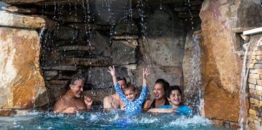 Florida pool grotto with family under waterfall