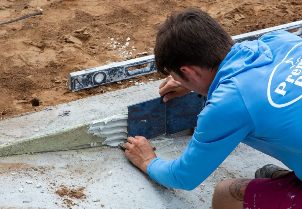 Premier Pools worker going through the pool construction process in orlando with a new pool build