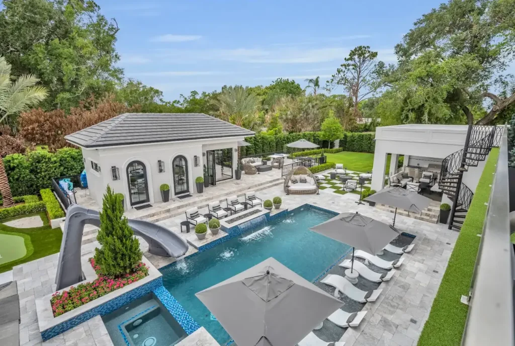 Luxury Pool Design in Florida with slide, sun shelf, and water feature