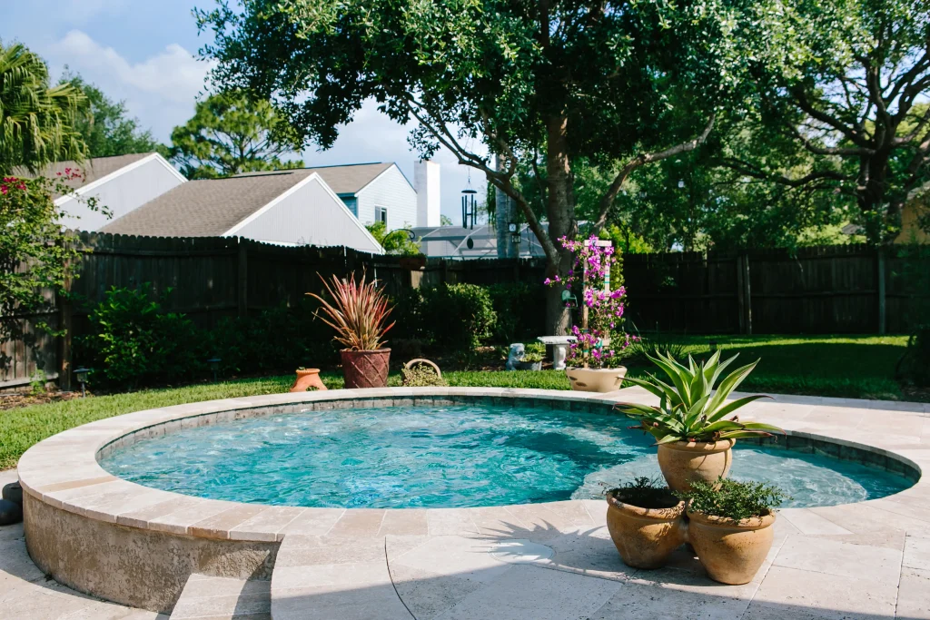 Small backyard pool in Orlando with plants next to it