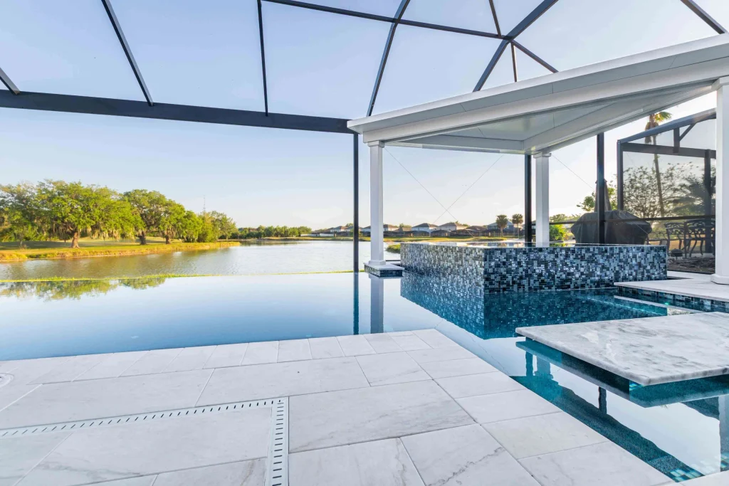 Infinity Pool Bar with a Screened in Deck and hot tub overlooking a lake in Orlando.