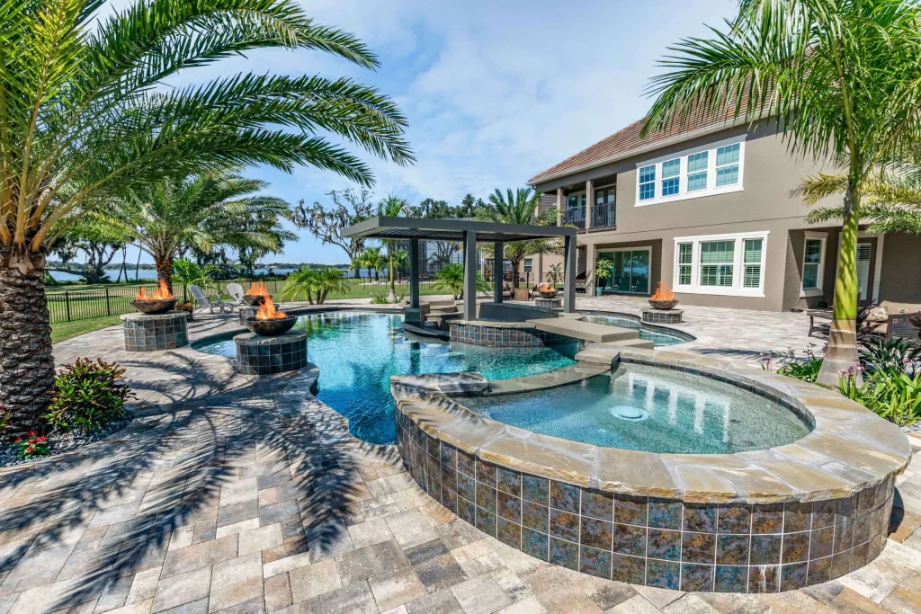 Luxury Backyard pool with a swim-up bar, hot tub, and fire features. 